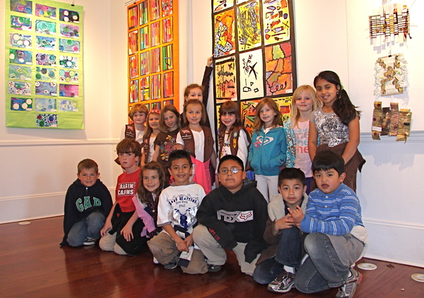 Springs School first-graders gather in front of their artwork at the school's student art exhibit at Ashawagh Hall on Friday.