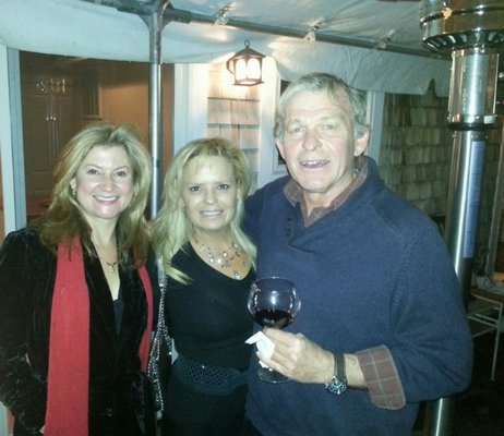 Maritza Jimenez, Amelia Doggwiler and Ed Haugevik stay warm next to a heatlamp on a covered deck in Sag Harbor.