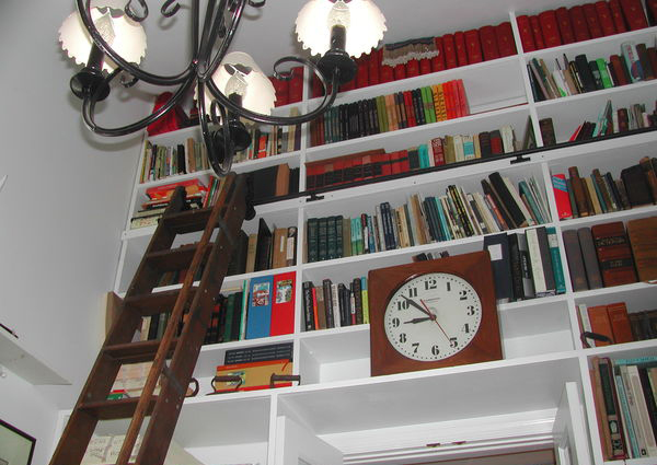 Paul Vogel's East Hampton home library; replete with rolling ladder and timepiece. BRANDI BUCHMAN