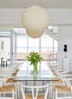 The dining room showcases a glass top table to reflect the bay view to the north, and natural cord seats to complement the marshland grasses beyond. CHRISTIAN HARDER