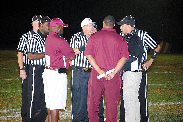 Coaches and referees huddle to decide disciplinary action after the brawl.  BRETT MAUSER