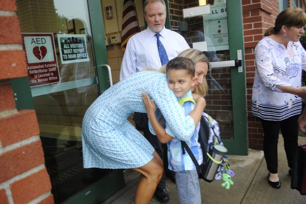 Logan Barnabee embraces his former teacher Kerri King outside East Quogue Elementary School on his first day of first grade. AMANDA BERNOCCO