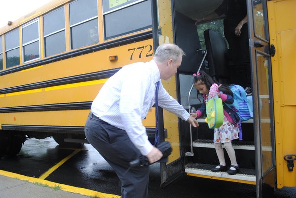 Superintendent Robert Long greets Sofia Penaloza as she gets off the bus for her first day of kindergarten. AMANDA BERNOCCO