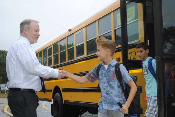 Superintendent Robert Long shakes hands with a student outside East Quogue Elementary School on the first day of school. AMANDA BERNOCCO