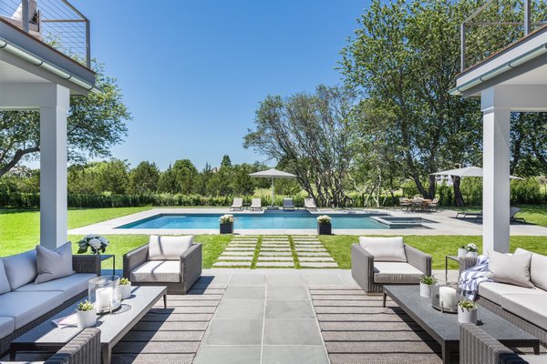 The outdoor living area includes lounge seating, a full kitchen, a gunite pool and hot tub and a dining area at Kristen Farrell's Home Show at 50 Lawrence Court in Water Mill. LENA YAREMENKO