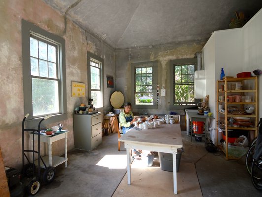 Meg Smeal in her century-old carriage house, converted to a working potter's studio. The open top of one of her kilns can be seen in the left corner. CHRIS ARNOLD