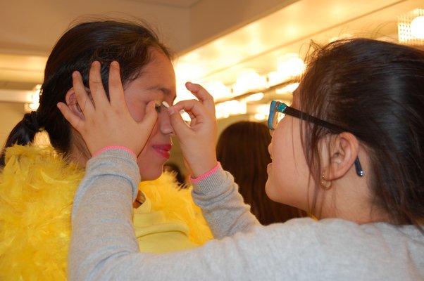 Nicole Castro, right, appliying makeup to Angie Guaman before she takes the stage. JON WINKLER