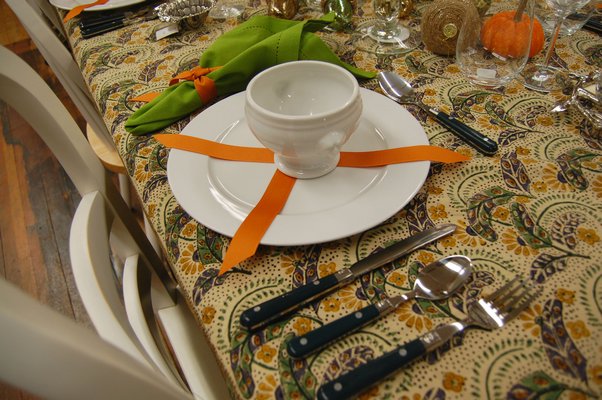 A table setting at Hildreth's uses orange ribbon for an easy, affordable, and decorative place setting. ERICA THOMPSON