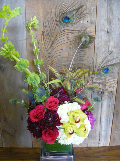 Hydrangea, roses, dahlias, thistle, cymbidium orchids, thistle, Bells of Ireland and peacock feathers make up another arrangement from Thorn Bird Floral Boutique. COURTESY ROBIN PREIATO