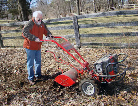 The Hampton Gardener tills a fallow vegetable garden with a Troy-Bilt rototiller.