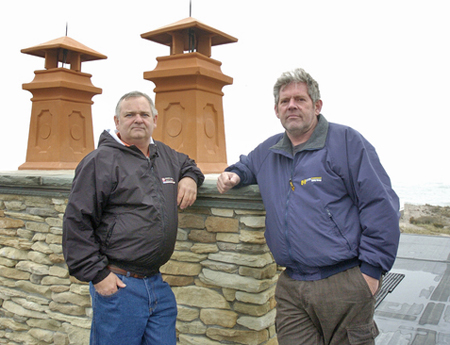 John Murtha and Bill Skinner of Applied Lightning Safety Group on the roof of a Quogue home outfitted with lightning rods.