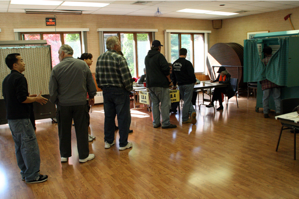 Voters in East Hampton wait to enter the voting booth.