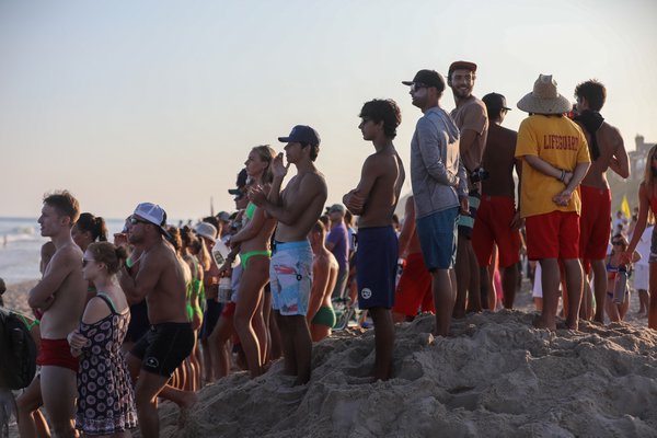 Spectators watch the run-swim-run from atop a dune.