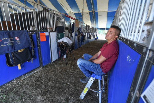 A groom waits while his horses are out in the ring competing.