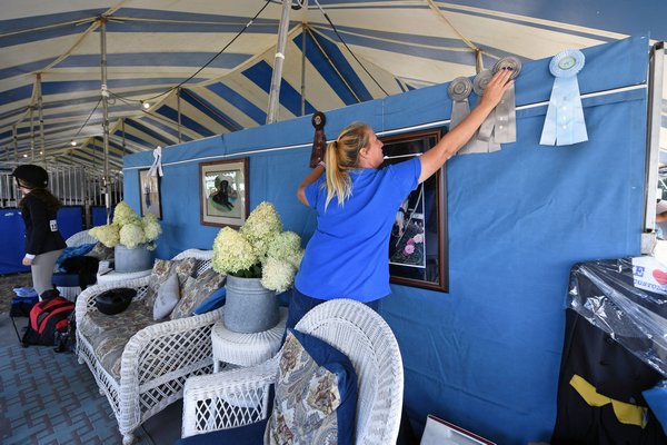 Swan Creek Stables trainer Katie Eberhardt hangs a ribbon on the wall of their temporary stable 