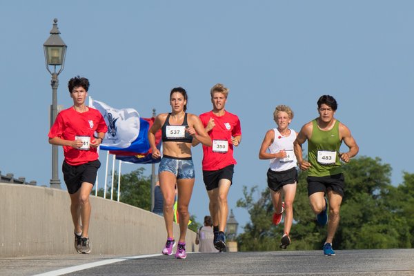 Paige Duca (overall champion) and Oscar Lorenza (second place) and the rest of the lead pack run over LCPL Jordan C. Haerter Veterans' Memorial Bridge during the third annual Jordan’s Run 5K.