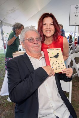 Dan Rizzie and Roseanne Cash with their book Bird on a Blade during the East Hampton Library's 15th Annual Authors Night Benefit under the tent at 555 Montauk Highway in Amagansett on Saturday.
