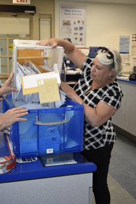 Jacqueline Carton on Monday at the Southampton Post Office collects the applications that had overflowed the PO box.