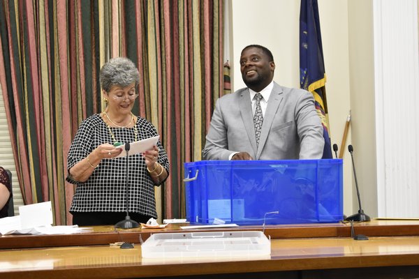 Southampton Housing Authority Director Curtis Highsmith Jr. draws an application from the bin as Diana Weir reads the name of an applicant.