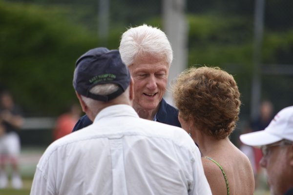 Former president Bill Clinton makes his way on to the field.