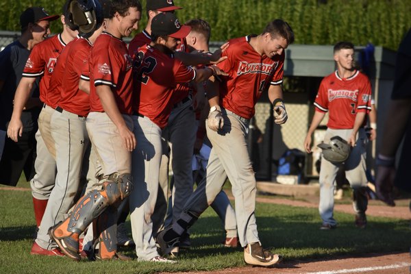 Eric Callahan (Millersville) gets mauled by his Westhampton teammates after his base hit in the ninth drove in the winning run.