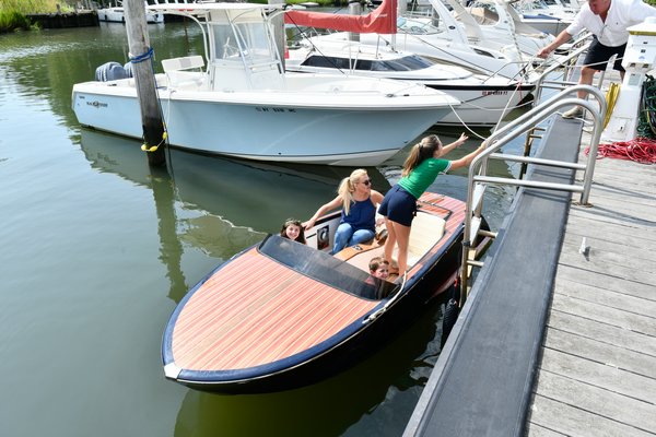 Sustainable Southampton Green Advisory Committee member Victoria Gorman takes Christopher and Isabella Glorioso and her daughter Marchella out for ride in the electric runabout boat. DANA SHAW