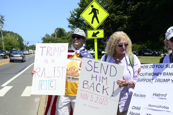 President Trump protesters and supporters lined Montauk Highway in Water Mill on Friday, in anticipation that he would eventually drive by. GREG WEHNER