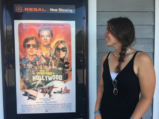 Lily Candelaria, 17, looks at the movie posters displayed outside of the Hampton Bays movie theater.