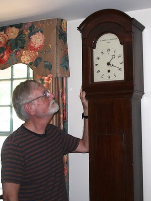 Richard Barons, chief curator of the East Hampton Historical Society at the Jackson Osborn House next to a Dominy clock.   KYRIL BROMLEY