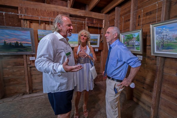 Michael Daly, Michelle Seitz and Jay Schneiderman converse during the annual Peconic Land Trust Gala at the Ocean View Farm in Bridgehampton on Sunday evening.