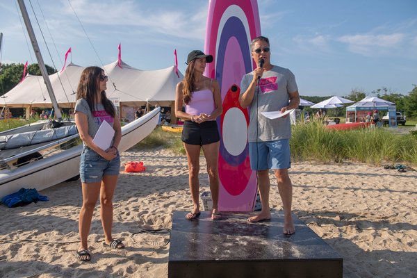 Paddle for Pink Co-Founder Larry Baum addresses the crowd as his wife Maria and Celebrity Chef and Guest of Honor Katie Lee look on prior to the start of the annual Paddle for Pink at Havens Beach on Saturday morning.