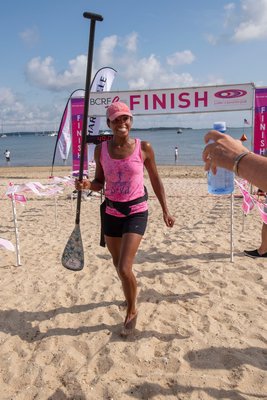 3-Mile First Place Female Winner Taryn Berkett (with a time of 43:41) crosses the finish line during the annual Paddle for Pink at Havens Beach on Saturday morning.