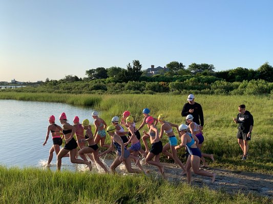 The girls enter the water to start the triathlon.