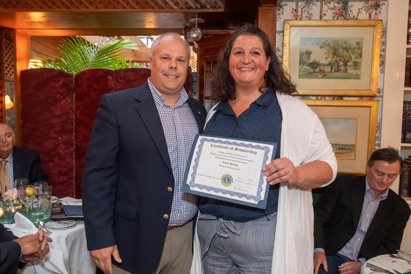 Mark Poitras, Chairman of the Scholarship Committee of the Sag Harbor Lions Club, presents Nancy Hallock, mother of Pierson High School Graduate Emily Hallock, with a $10,000 Certificate of Scholarship on behalf of Emily - who was away in Africa - during the Lions Club Awards Dinner at the American Hotel on July 24.