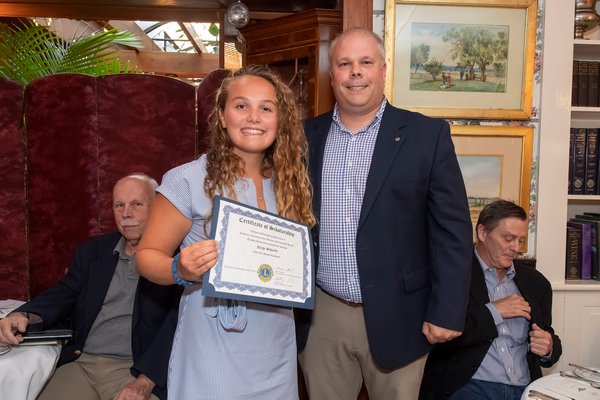 Mark Poitras, Chairman of the Scholarship Committee of the Sag Harbor Lions Club, presents Pierson High School Graduate Paige Schaefer with a $20,000 Certificate of Scholarship during the Lions Club Awards Dinner at the American Hotel on July 24.