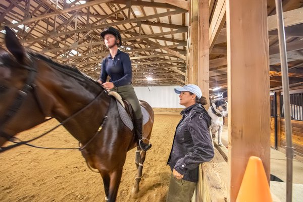 Trainer Mandy Topping gives pointers (along with her pal Rudy) to Lucy Beeton as she trains for competition at the Hampton Classic at the Swan Creek Farm Stables in Bridgehampton on August 13.