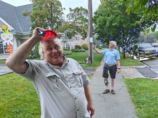 Doug Sullivan takes a picture of Mike Zotos's work in front of Harbor Hot Tubs.