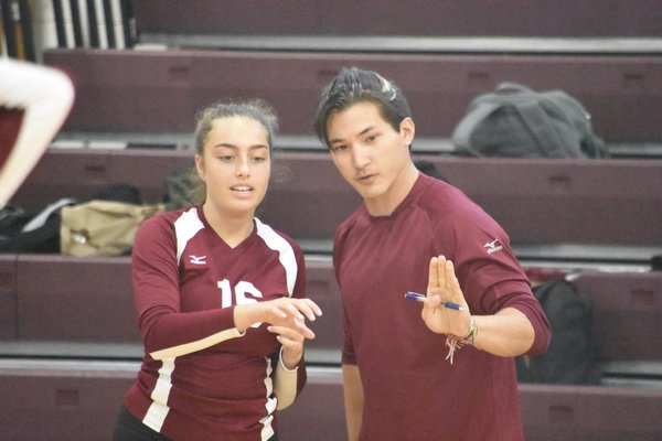 Alex Choi, in his first ever varsity match as head coach, teaches his sophomore Sorrel Miller during Wednesday's match.