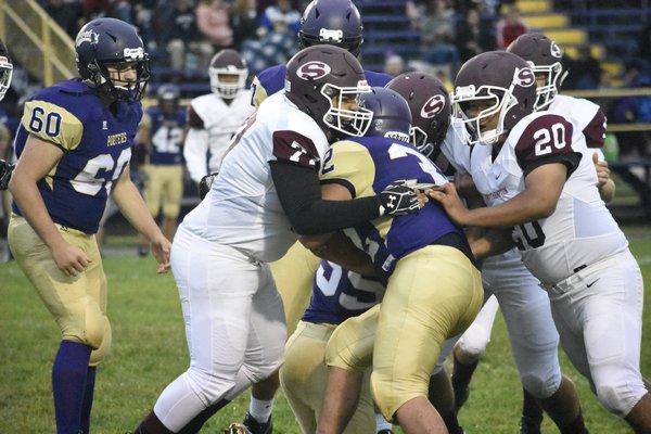 Reginald Morris gets help from him his teammates to bring down Greenport's Devin Toman.