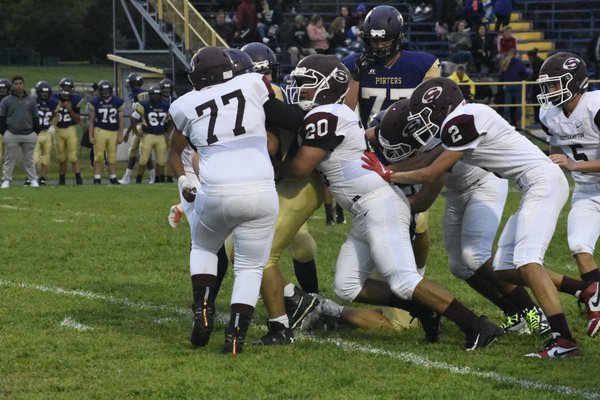 Reginald Morris gets help from him his teammates to bring down Greenport's Devin Toman.