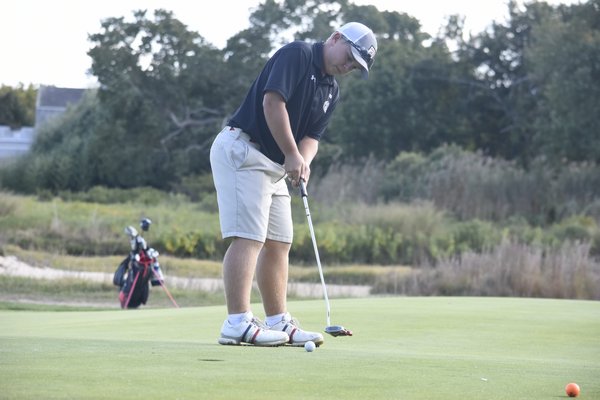 Westhampton Beach senior Cole Federico putts his ball on the first hole.