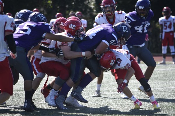 Hampton Bays sophomore Cooper Shay barrels ahead with multiple Center Moriches defenders trying to bring him down.