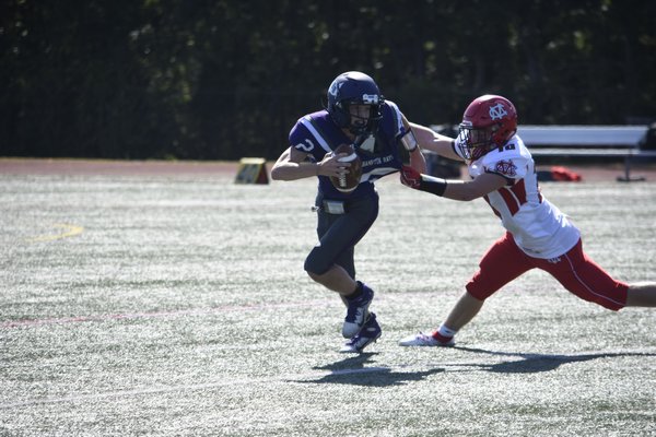 Senior quarterback Lucas Brown eludes a Center Moriches defender and breaks a long run, which was key in leading to the Baymen's first touchdown of the season.