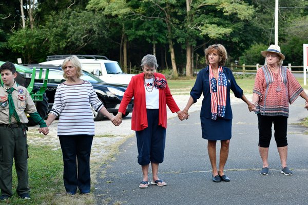 People join hands at the September 11 remembrance at the North Sea Community House on Wednesday morning.