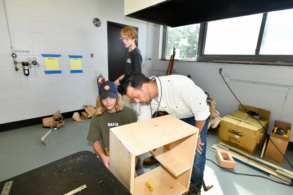 Carpentry teacher Benny Diaz works with Tim Kadash in the shop. DANA SHAW