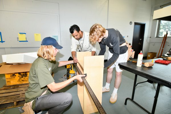 Carpentry teacher Benny Diaz works with students Tim Kadash and Atticus Jaques in the shop at Southampton High School. DANA SHAW