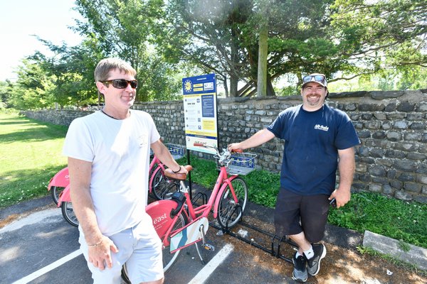 Patrick O'Donoghue and Chris Dimon at the Pedalshare station at Agawam Park in Southampton Village in July. DANA SHAW
