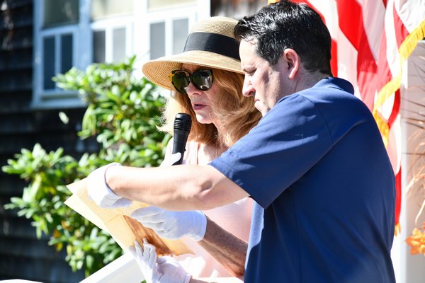 Parishioner Lauren Culver Barlow and church historian Ryan Elliott read some of the correspondence from the metal container hidden behind the cornerstone at a ceremony on Saturday. DANA SHAW