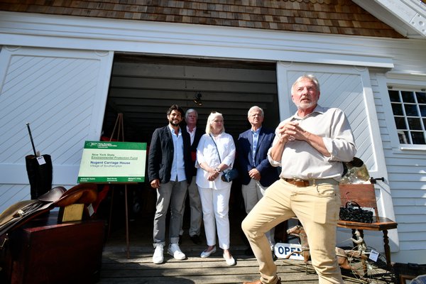 Tom Edmonds, far right, executive director of the Southampton History Museum along with Southampton Village Mayor Jesse Warren, Nancy McGann, president of the Southampton History Museum, and New York State Assemblyman Fred W. Thiele Jr., welcome visitors to the grand opening of the Nugent Carriage House in early August. The building was recently rehabilitated using funds from the NYS Environmental Protection Fund and the Village of Southampton. The shop is open Fridays and Saturdays until October 12, from 11 a.m. to 4 p.m. DANA SHAW