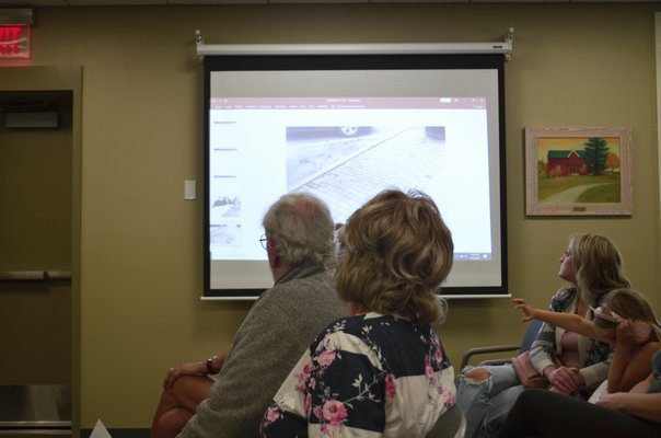 Westhampton Beach residents viewing slides from Sandpebble that explain why SCWA has to conduct certain aspects of its work. ANISAH ABDULLAH